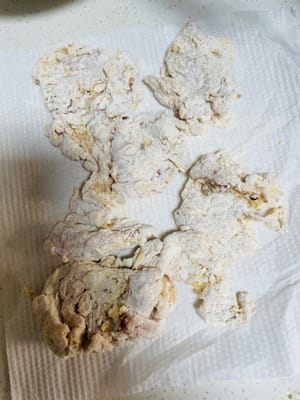 5. 衣をつけた鶏もも肉を小麦粉の衣に入れ、手で何度もこねてこすり合わせ、できるだけ小麦粉をまぶします。後で使うので、お皿に盛り付けます（面倒な方はキッチンペーパーの上に置いても構いません）。