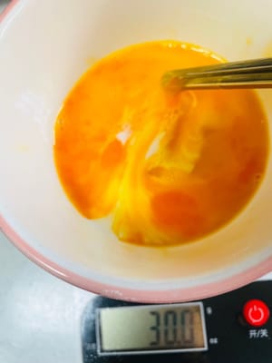 生地を作る：別のボウルに卵液30gと牛乳25gを入れ、先ほどの衣粉30gを加えて混ぜ、なめらかな生地になるまで混ぜます。