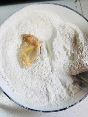 5. 衣をつけた鶏もも肉を小麦粉の衣に入れ、手で何度もこねてこすり合わせ、できるだけ小麦粉をまぶします。後で使うので、お皿に盛り付けます（面倒な方はキッチンペーパーの上に置いても構いません）。
