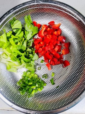 Tagliare i cipollotti e il sedano a spicchi e tritare i peperoncini rossi. Preparare tutti gli ingredienti.
