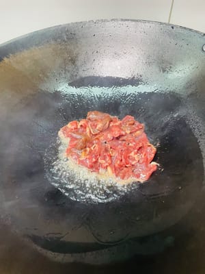 Scaldare l'olio in un wok, aggiungere la carne marinata, soffriggere velocemente a fuoco vivo finché non cambia colore, quindi toglierla dal wok (non cuocerla troppo). Aggiungere il sedano e i peperoncini rossi e soffriggere brevemente finché non sono cotti.