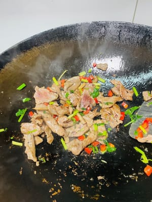 Scaldare l'olio in un wok, aggiungere la carne marinata, soffriggere velocemente a fuoco vivo finché non cambia colore, quindi toglierla dal wok (non cuocerla troppo). Aggiungere il sedano e i peperoncini rossi e soffriggere brevemente finché non sono cotti.