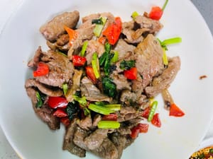 Scaldare l'olio in un wok, aggiungere la carne marinata, soffriggere velocemente a fuoco vivo finché non cambia colore, quindi toglierla dal wok (non cuocerla troppo). Aggiungere il sedano e i peperoncini rossi e soffriggere brevemente finché non sono cotti.