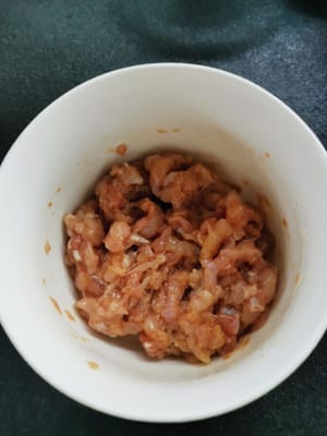 Den Kan in einen Behälter geben, würzen (Salz, Pfefferpulver, Sojasauce, Zucker, Tapiokamehl und Öl), marinieren und 10 Minuten ruhen lassen.