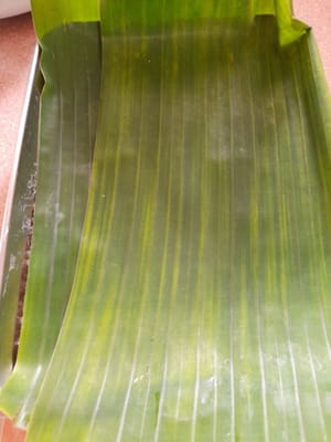 Prepare un molde para hornear, engráselo con un poco de aceite de cocina y vierta la mezcla de wajik. Presione hasta que esté compacta y cubra la superficie con plástico y hojas de plátano.