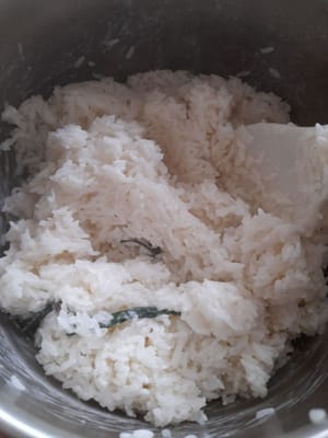もち米を15分蒸した後、取り出して容器に入れ、先ほど茹でておいたココナッツミルクと混ぜ合わせ、よくかき混ぜながらさらに20分蒸します。置いてから蓋をします。