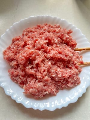 將豬絞肉用鹽、糖、豉油、料酒和玉米澱粉醃製。攪拌均勻