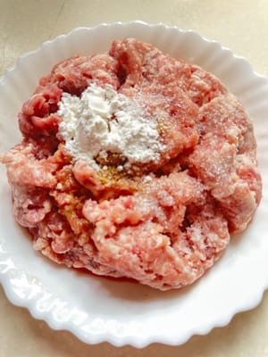 將豬絞肉用鹽、糖、豉油、料酒和玉米澱粉醃製。攪拌均勻