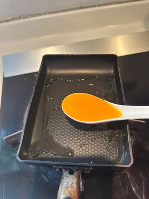 在一個小的長方形鍋中，鋪上一湯匙蛋液