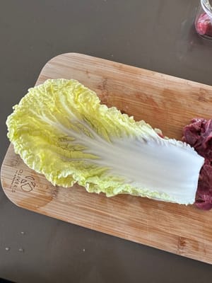Layer sliced beef onto cabbage as demonstrated