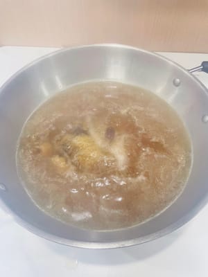 Vierte el caldo preparado en la olla caliente y vuelve a hervirlo. Agrega el pollo limpio y cocina a fuego alto durante 2 minutos. Apaga el fuego inmediatamente, tapa y deja cocer a fuego lento durante 9 minutos hasta que el pollo esté tierno y jugoso. ¡Listo para comer! Primero, disfruta de un tazón del dulce caldo y luego sumérgelo en la salsa perfecta de jengibre o ajo picado. ¡Absolutamente delicioso!