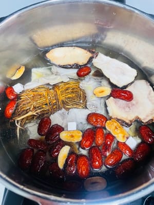 Coloca los huesos escaldados y todos los ingredientes del caldo remojado en una olla de barro y llénala de agua. Lleva a ebullición a fuego alto, luego reduce el fuego y cocina a fuego lento durante 1 hora. Si tienes prisa, usa una olla a presión y cocina durante 15 minutos después de que alcance la presión, luego deja que se libere naturalmente.

¡Aquí está el secreto! Agregar carcasa de pollo y huesos de cerdo al caldo le dará un sabor mucho más intenso que si solo usas pollo, ¡con un gusto excepcionalmente dulce y delicado!