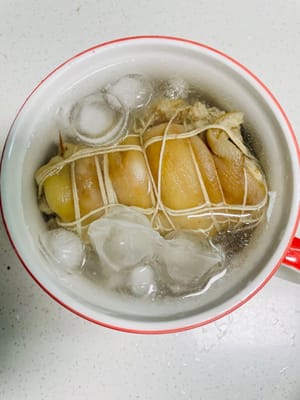 Sciacquare gli involtini di carne cotti con acqua tiepida e immergerli immediatamente in acqua ghiacciata per raffreddarli.

La dilatazione e la contrazione termica durante il raffreddamento fanno sì che la carne si restringa all'istante, conferendole una consistenza più croccante e gommosa: un passaggio fondamentale per ottenere la consistenza tenera e croccante dello stinco di maiale bollito!