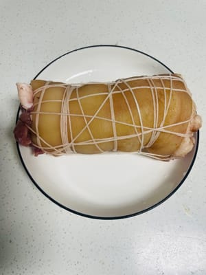 Togliere gli involtini di carne dal frigorifero, strappare la pellicola trasparente e legarli strettamente con uno spago di cotone per evitare che si sfaldino durante la cottura.