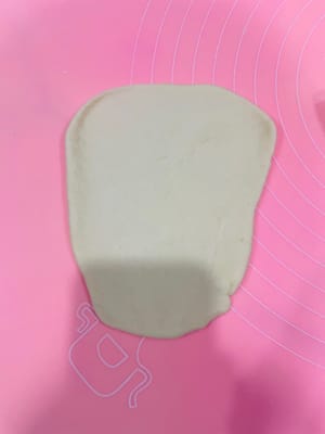 塑形捲製:取麵劑擀成上大下小的形狀,在窄邊抹餡,從窄邊開始卷,邊捲邊收緊兩邊防露餡。
