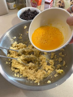 Agregue 100 g de huevo batido 2 o 3 veces. Asegúrese de integrar bien el huevo batido en la masa antes de añadir más. No lo vierta todo de golpe.
