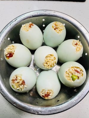 用小湯匙把糯米餡兒慢慢塞進鹹蛋殼裡,輕輕壓實(別太暴力,不然蛋殼會破),餡料塞緊點,蒸出嚟不會鬆散,口感更紮實。