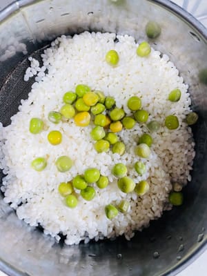 Escurra el arroz glutinoso remojado, añada salchicha china en cubos y guisantes, media cucharada de salsa de soja ligera, una cucharadita de salsa de ostras y una cucharadita de manteca de cerdo (la manteca sólida se puede derretir en el microondas durante 10 segundos) y mezcle bien. La manteca de cerdo le da al arroz glutinoso más jugosidad y aroma; ¡es el alma de la cocina cantonesa!