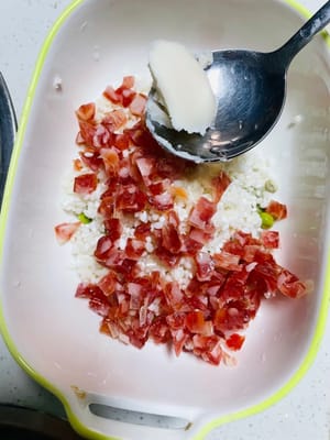 Escurra el arroz glutinoso remojado, añada salchicha china en cubos y guisantes, media cucharada de salsa de soja ligera, una cucharadita de salsa de ostras y una cucharadita de manteca de cerdo (la manteca sólida se puede derretir en el microondas durante 10 segundos) y mezcle bien. La manteca de cerdo le da al arroz glutinoso más jugosidad y aroma; ¡es el alma de la cocina cantonesa!