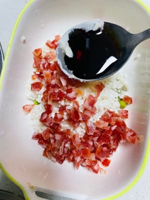 Escurra el arroz glutinoso remojado, añada salchicha china en cubos y guisantes, media cucharada de salsa de soja ligera, una cucharadita de salsa de ostras y una cucharadita de manteca de cerdo (la manteca sólida se puede derretir en el microondas durante 10 segundos) y mezcle bien. La manteca de cerdo le da al arroz glutinoso más jugosidad y aroma; ¡es el alma de la cocina cantonesa!