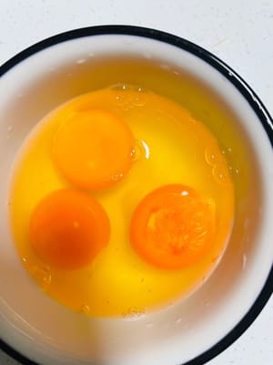 การเตรียมไข่: ตอกไข่อีกฟองลงในชามแล้วคนด้วยตะเกียบอย่างแรงจนไข่ขาวและไข่แดงผสมเข้ากันดี