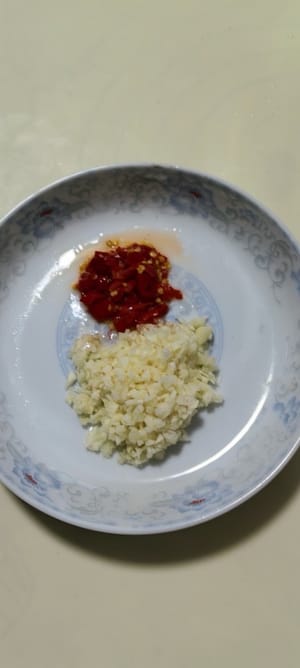 Faites chauffer l'huile, ajoutez l'ail et le poivron rouge hachés, puis ajoutez les champignons blanchis.