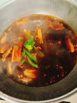 Selanjutnya, rebus sepanci air. Tambahkan bumbu-bumbu: jahe yang sudah disiapkan, daun bawang yang sudah dibentuk simpul, lada Sichuan, cabai kering, 25 gram bumbu tumis Erjie, satu sendok makan kecap asin encer (Anda bisa menambahkan sedikit kecap asin pekat untuk warna jika ada), dan tiga gram garam.