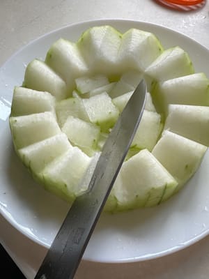 ตัดด้านข้างของแตงโมออกให้เป็นรูปซิกแซก วางแตงโมที่ตัดแต่งแล้วไว้ตรงกลางเป็นฐาน