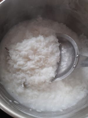将椰奶和水（600毫升）煮沸，然后加入米（我之前浸泡过1小时的米）、盐、月桂叶和香茅。继续搅拌直至水完全吸收，备用。
