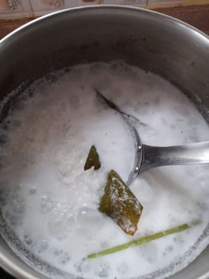 将椰奶和水（600毫升）煮沸，然后加入米（我之前浸泡过1小时的米）、盐、月桂叶和香茅。继续搅拌直至水完全吸收，备用。