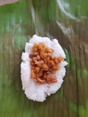 Ambil selembar daun pisang ,taruh 2-3 sendok makan nasi ,pipihkan.Tambahkan 1-2 sendok teh isian ditengah ,gulung dan padatkan.