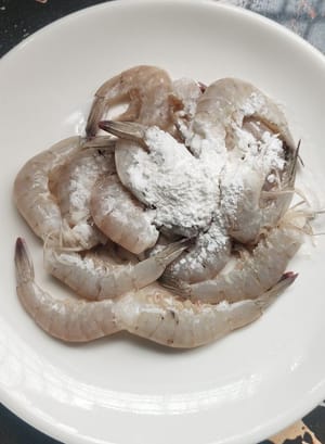 Remove the heads and innards from the shrimp, devein them, wash them thoroughly, drain the water, then sprinkle with a layer of cornstarch and mix well. Steam the oysters for two minutes until they open their shells automatically, remove the oyster meat, wash it clean, and coat it with cornstarch as well.