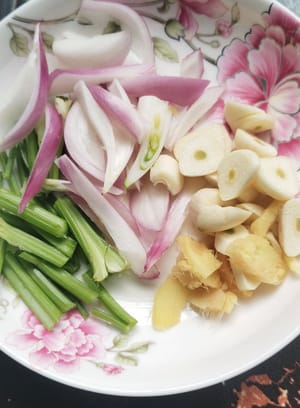 Cut celery into sections, coarsely slice onion, and slice ginger and garlic.