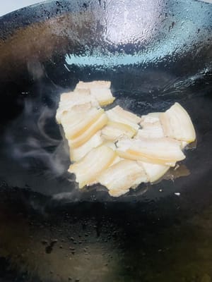 Menggoreng perut babi: Masukkan dua sendok makan minyak goreng ke dalam wajan, panaskan, lalu masukkan irisan perut babi dan goreng hingga berwarna cokelat keemasan di kedua sisinya (hati-hati dengan cipratan minyak, gunakan penutup untuk mencegah luka bakar), lalu angkat dan sisihkan.