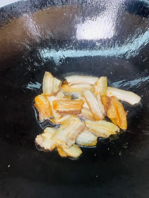 Menggoreng perut babi: Masukkan dua sendok makan minyak goreng ke dalam wajan, panaskan, lalu masukkan irisan perut babi dan goreng hingga berwarna cokelat keemasan di kedua sisinya (hati-hati dengan cipratan minyak, gunakan penutup untuk mencegah luka bakar), lalu angkat dan sisihkan.