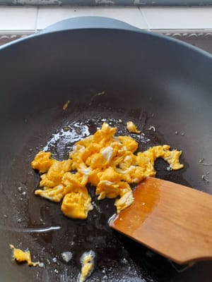 Aggiungere le uova strapazzate e cuocere finché non saranno cotte, quindi toglierle e scolarle.