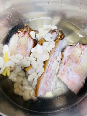 Karena kaki babi yang diawetkan mengandung banyak garam selama proses memasak, kaki babi tersebut harus dimasak hingga matang sempurna bersama kacang merah putih yang sulit dimasak. Jika Anda menggunakan panci presto, nyalakan timer selama 3 menit setelah panci presto habis; jika Anda menggunakan panci biasa, Anda perlu memasak lebih dari 20 menit. Setelah matang, buang air rebusan pertama karena terlalu asin.