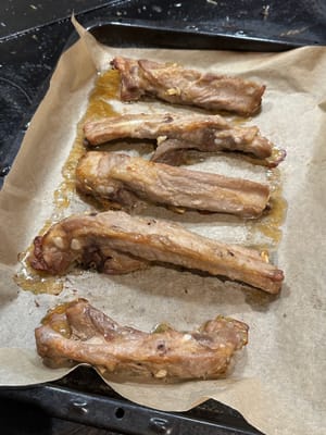Tapisser les côtes de porc sur une plaque de cuisson et retirer toute citronnelle collée dessus