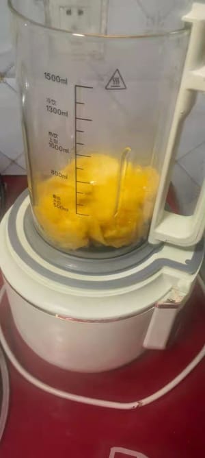 Den größten Teil davon mit Milch in einen Mixer geben und zu einem schön gefärbten Mango-Smoothie pürieren.