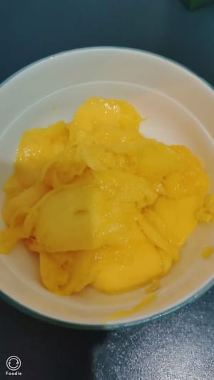 Die Mango halbieren und versuchen, das Fruchtfleisch auf jede erdenkliche Weise herauszulösen.