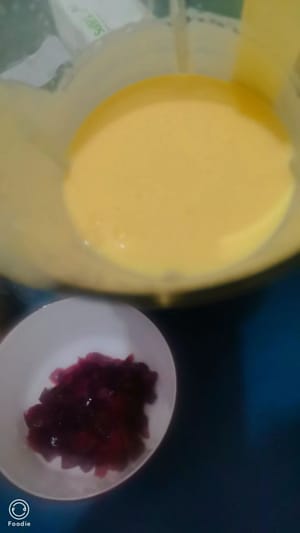 Den größten Teil davon mit Milch in einen Mixer geben und zu einem schön gefärbten Mango-Smoothie pürieren.