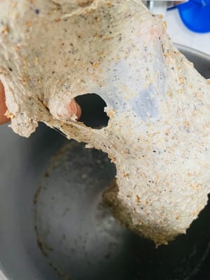 揉面至无颗粒、无干粉状,加入黄油继续揉,至面团出现6分膜(拉开呈锯齿状,因含粗粮和黑芝麻粉,延展性稍差)。
我以前做这款包是用橄榄油代替黄油。