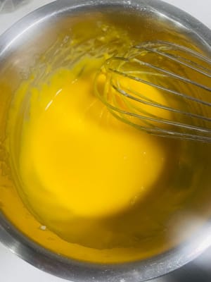 Separate and mix the eggs. In another bowl, separate the egg whites and yolks of 5 eggs: put the egg whites in a new bowl (remember the bowl must be oil-free and water-free!), pour the egg yolks into the bowl with the batter, and continue to mix using a Z-shaped motion until well combined.