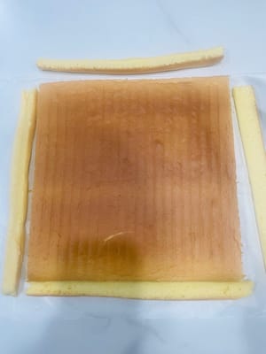 Trimming the cake crust. Place the cooled cake crust face up and trim 1cm off each of the four sides (neat trimming makes it easier to roll, and irregular edges will result in a harder texture).