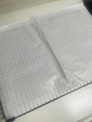 케이크 크러스트 식히기. 굽고 나면 케이크 크러스트를 식힘망에 뒤집어 놓습니다. 먼저 바닥의 유산지를 벗겨낸 후 새 유산지로 덮습니다. (케이크 크러스트를 뒤집어 유산지로 덮으면 케이크 크러스트가 마르고 갈라지는 것을 방지할 수 있습니다. 자연 식혀야 합니다.)