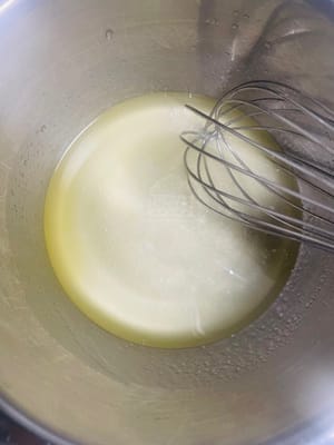 Prepare the batter base. In one bowl, add 50g water/milk, 50g corn oil, and 20g white sugar, and stir well (mixing the liquid ingredients first will make the batter smoother).
