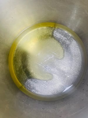 반죽 베이스를 준비합니다. 한 그릇에 물/우유 50g, 옥수수유 50g, 백설탕 20g을 넣고 잘 저어줍니다. (액상 재료를 먼저 섞으면 반죽이 더 부드러워집니다.)