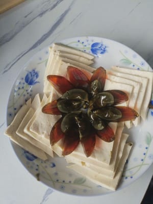 Letakkan potongan kecil telur yang diawetkan di atas tahu putih.