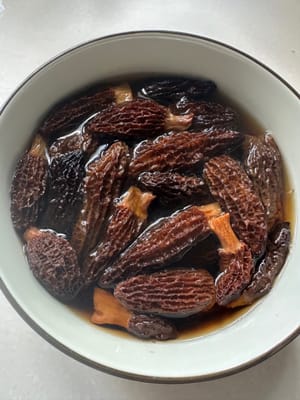 羊肚菌浸泡20分钟后，用清水洗两次，因为羊肚菌的形状容易藏沙子，清洗不干净，会影响口感，挤干水分备用，