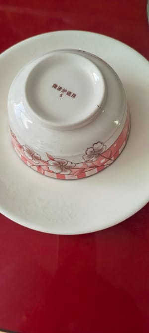 用一個盤子蓋上碗中食材，然後跟盤碗一起翻轉，拿掉上面的碗，擺入秋葵盤中造型。